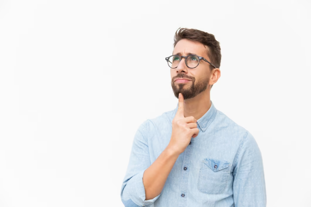 A man pointing to his chin while looking upward