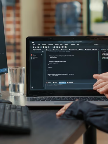 a woman is sitting in the office using a notebook and computer coding