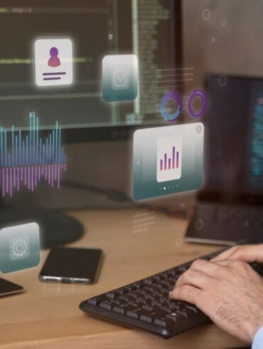 Hands typing with digital data icons over a dual-screen coding setup