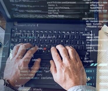 Man typing program code on computer
